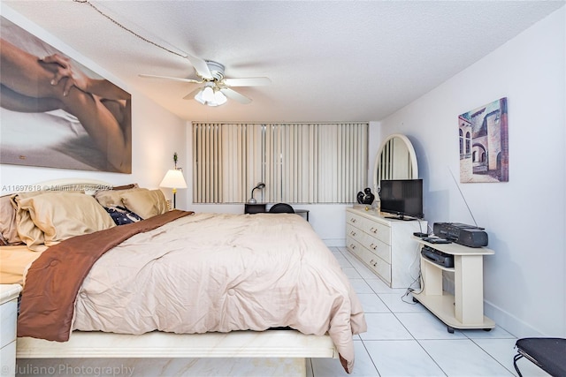 tiled bedroom featuring ceiling fan and a textured ceiling