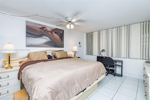 tiled bedroom with ceiling fan and a textured ceiling