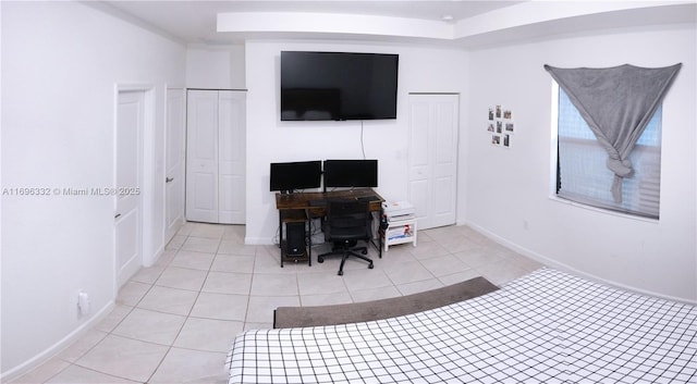 bedroom with light tile patterned flooring and baseboards