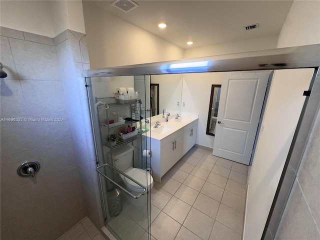 bathroom featuring a shower with door, vanity, and tile patterned flooring