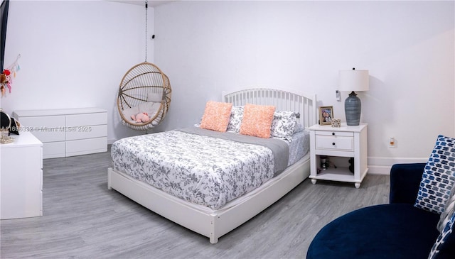 bedroom with baseboards and wood finished floors
