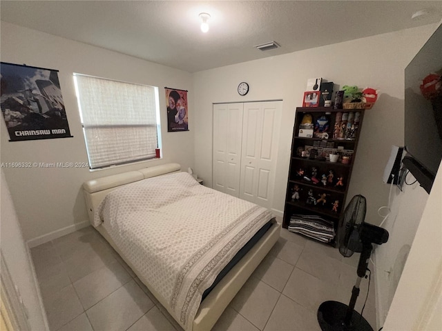 bedroom with light tile patterned floors and a closet