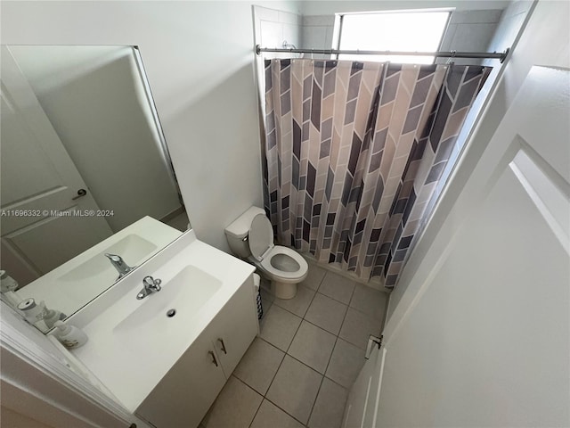 full bathroom featuring tile patterned flooring, vanity, toilet, and shower / bath combo with shower curtain