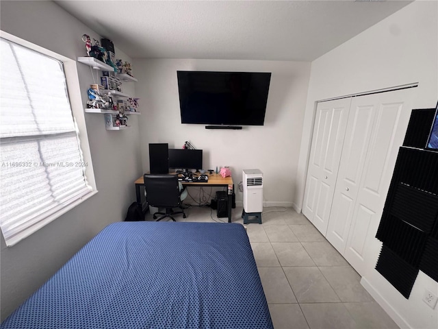 tiled bedroom with a closet