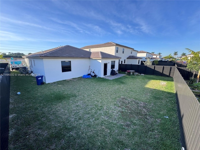 rear view of property featuring a lawn