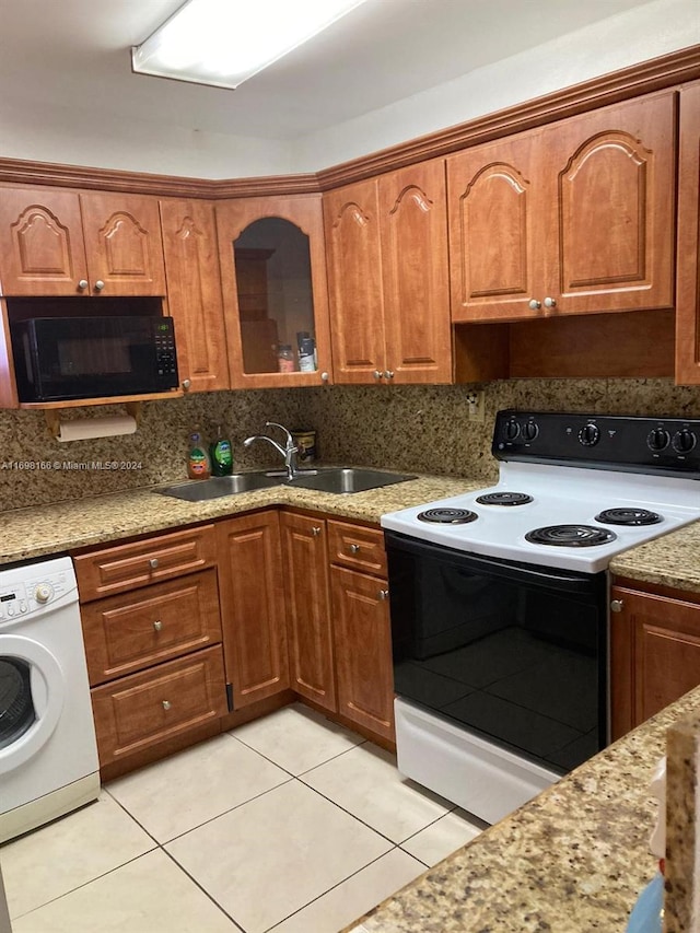 kitchen with washer / dryer, electric range, light tile patterned flooring, and sink