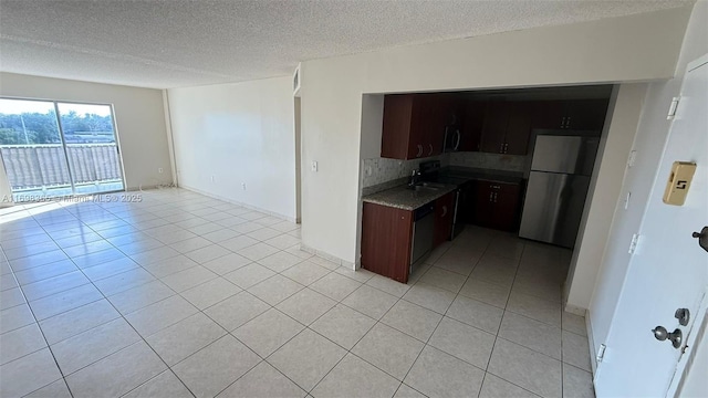 kitchen featuring light tile patterned floors, sink, stainless steel fridge, a textured ceiling, and decorative backsplash