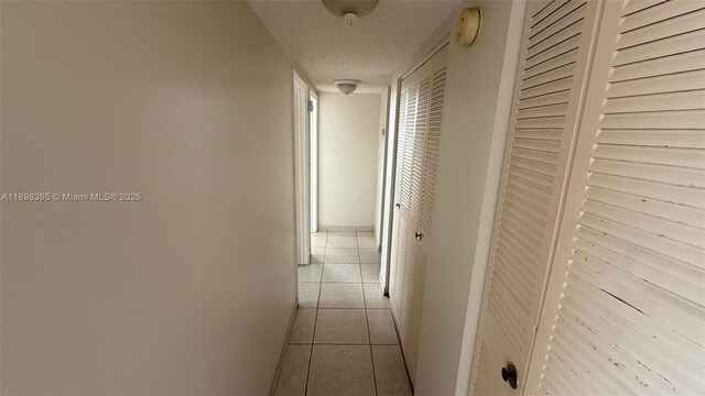 tiled empty room featuring a textured ceiling