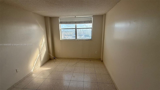 tiled spare room featuring a textured ceiling