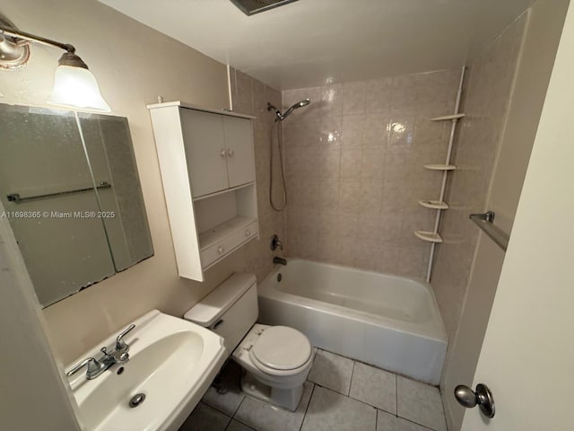 full bathroom with tiled shower / bath, tile patterned floors, toilet, and sink