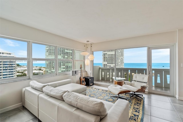 living room with plenty of natural light, a water view, and light tile patterned flooring