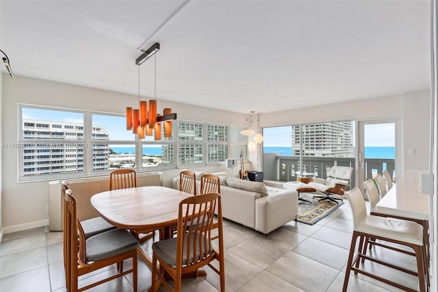 dining space featuring a water view, a wealth of natural light, and a notable chandelier