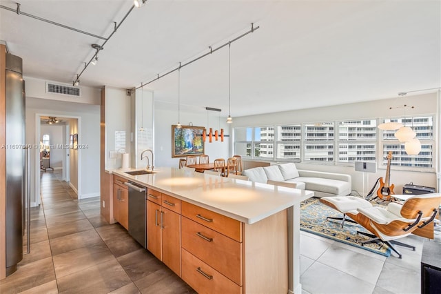 kitchen with sink, stainless steel dishwasher, decorative light fixtures, a center island with sink, and light tile patterned flooring