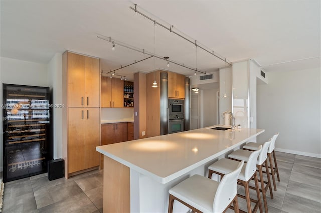 kitchen featuring rail lighting, a breakfast bar area, and sink