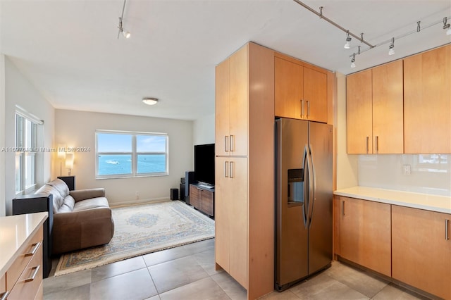 kitchen featuring stainless steel fridge with ice dispenser, track lighting, light brown cabinetry, and light tile patterned flooring