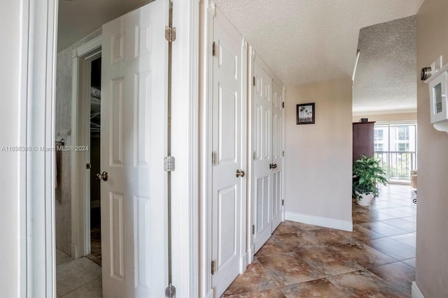 hallway with light tile patterned floors and a textured ceiling