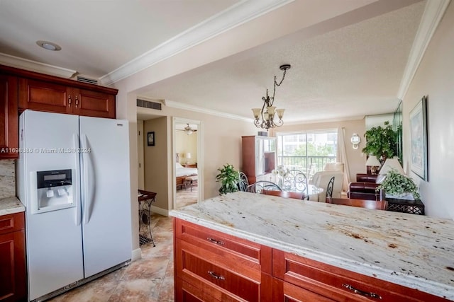 kitchen featuring white refrigerator with ice dispenser, pendant lighting, light stone countertops, and crown molding