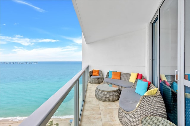 balcony featuring a view of the beach and a water view