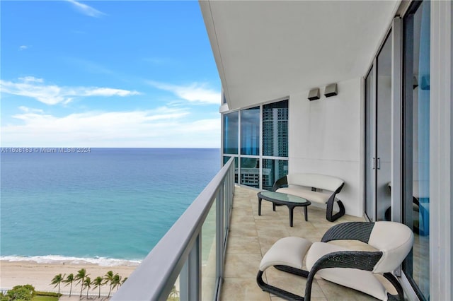 balcony with a water view and a view of the beach