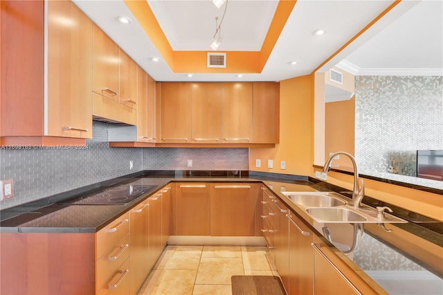 kitchen featuring backsplash, black electric cooktop, crown molding, and sink