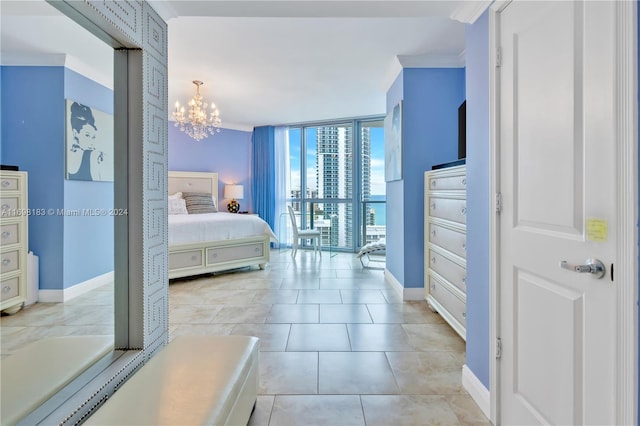 bedroom featuring floor to ceiling windows, crown molding, light tile patterned floors, and a notable chandelier