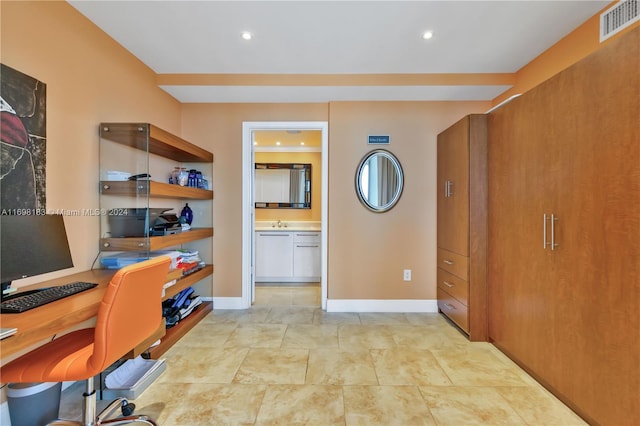 home office featuring built in desk and sink