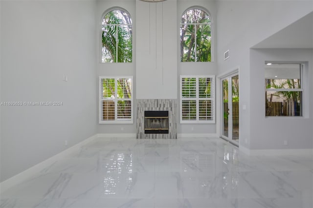 unfurnished living room with a towering ceiling and plenty of natural light