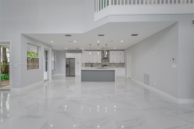 kitchen featuring white cabinetry, a center island, wall chimney exhaust hood, and stainless steel refrigerator with ice dispenser