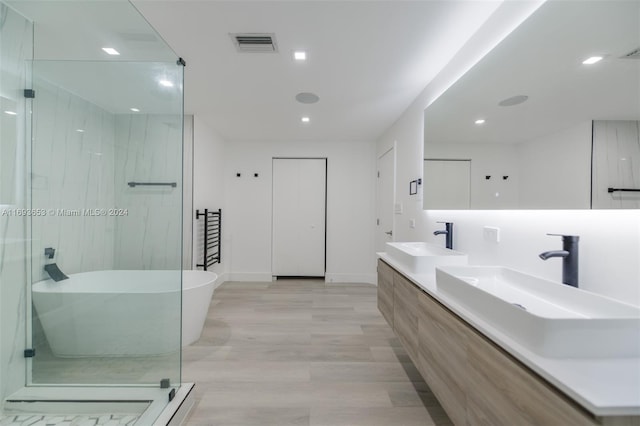 bathroom with hardwood / wood-style flooring, vanity, and separate shower and tub