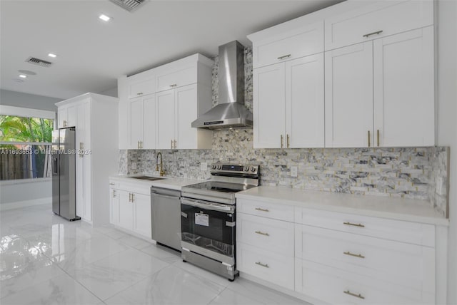 kitchen with white cabinets, sink, wall chimney exhaust hood, decorative backsplash, and stainless steel appliances