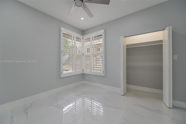 unfurnished bedroom with ceiling fan and a closet