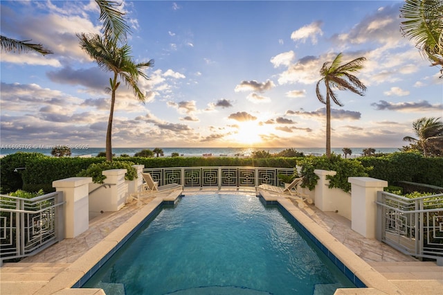 view of swimming pool with a water view, a fenced in pool, and a patio