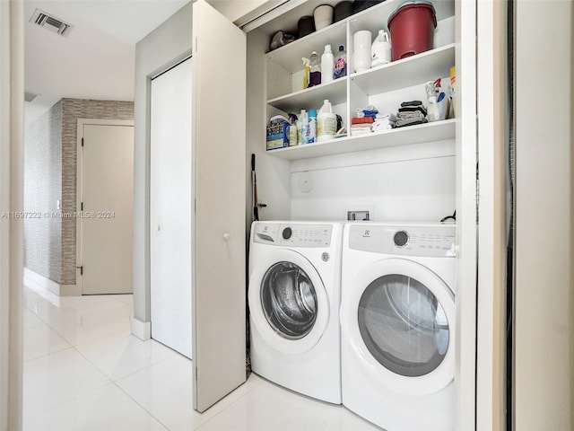 washroom featuring washing machine and dryer and light tile patterned floors