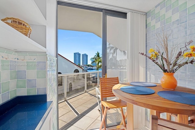 dining space with tile patterned floors, a city view, and tile walls