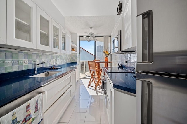 kitchen featuring a sink, decorative backsplash, dark countertops, and stainless steel appliances