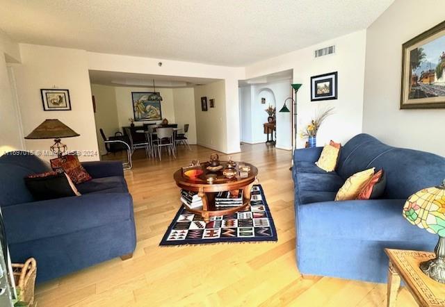 living room featuring wood-type flooring and a textured ceiling