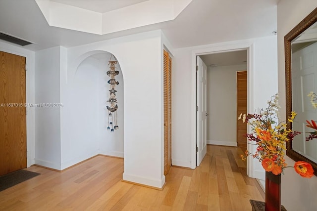 corridor with light wood-style flooring and baseboards