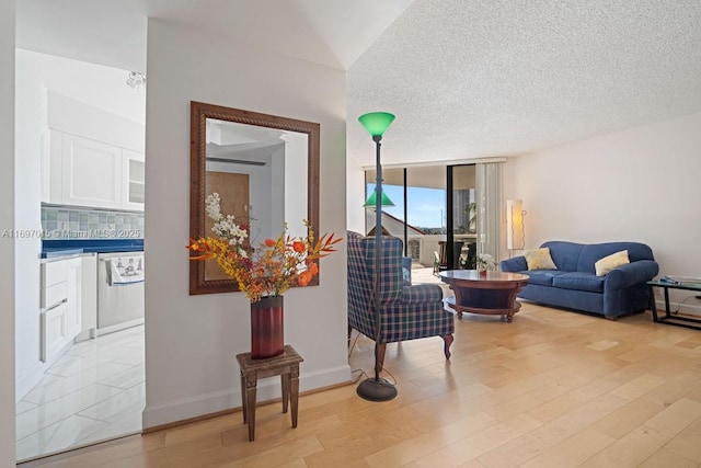 interior space featuring expansive windows, a textured ceiling, baseboards, and wood finished floors