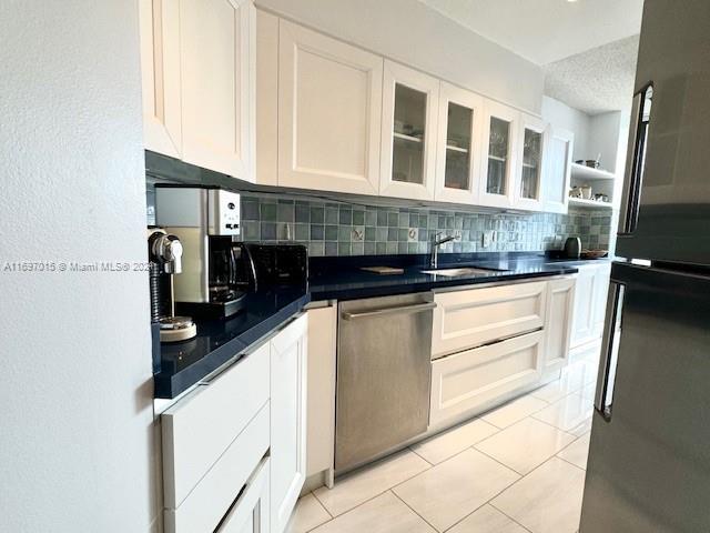 kitchen with tasteful backsplash, white cabinetry, and stainless steel appliances