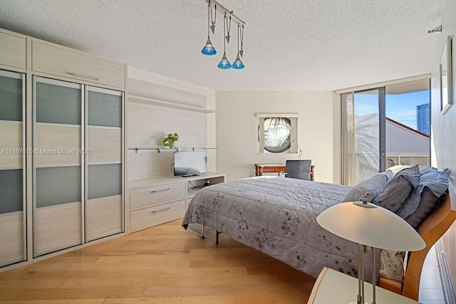 bedroom with a textured ceiling and light wood-type flooring