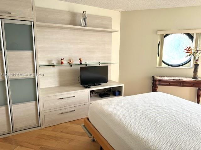 bedroom featuring a textured ceiling and light wood-type flooring