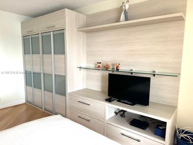 bedroom featuring a closet, a textured ceiling, and hardwood / wood-style flooring