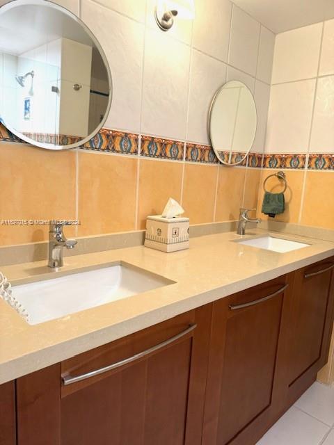 bathroom featuring tasteful backsplash, tile patterned flooring, vanity, and tile walls