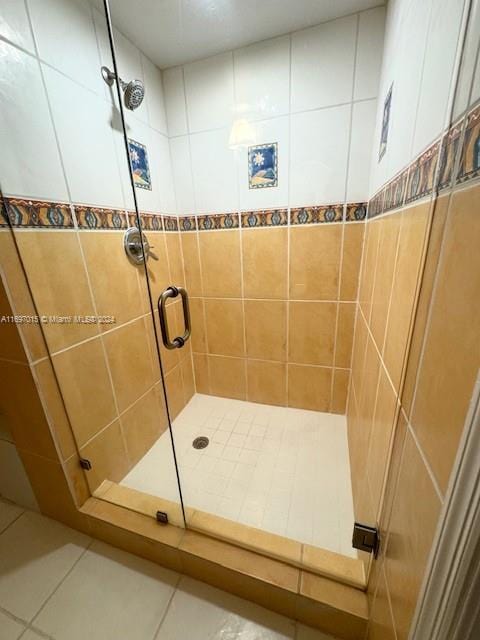 bathroom featuring tile patterned floors, tile walls, and walk in shower