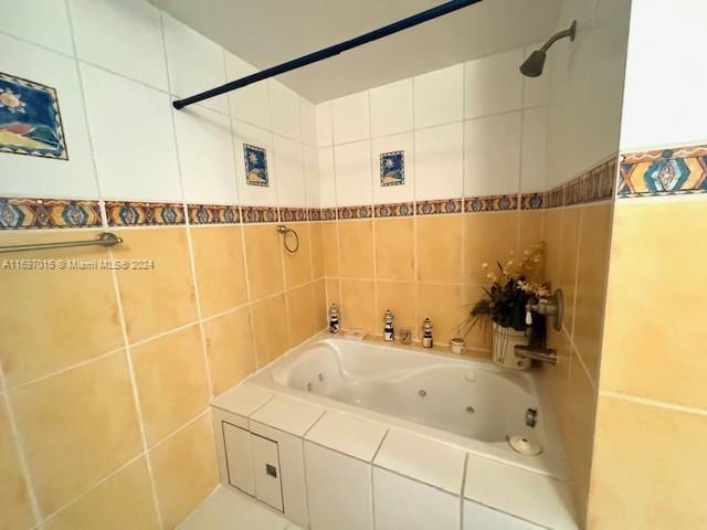 bathroom featuring tiled shower / bath combo and tile walls