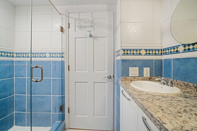 bathroom featuring vanity, tile walls, and a shower stall