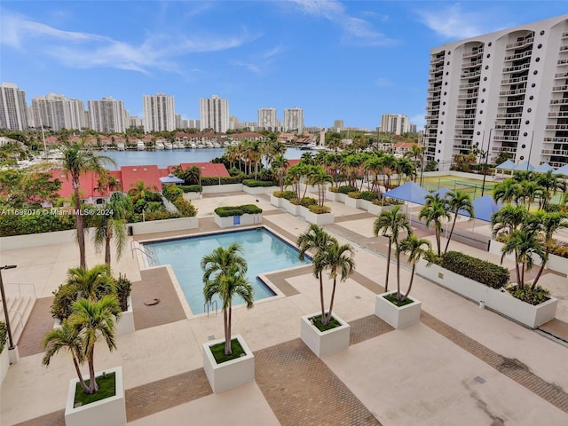 view of pool featuring a patio area and a water view