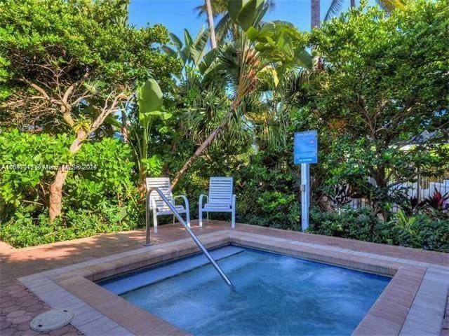 view of swimming pool with an in ground hot tub