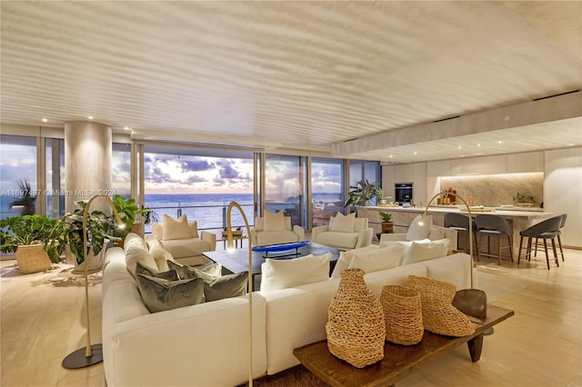 living room with a water view and a wall of windows