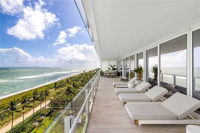 balcony with a water view and a view of the beach